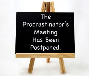 Chalk-Board Sign. The Procrastinators Meeting has been postponed. Stop Procrastinating.