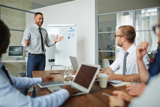 A man standing in front of a group leading a productive meeting Meetings