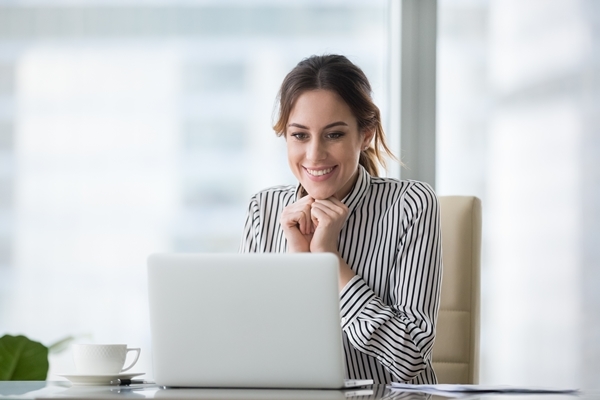 Happy smiling young woman looking at laptop screen. Outlook Reading Pane