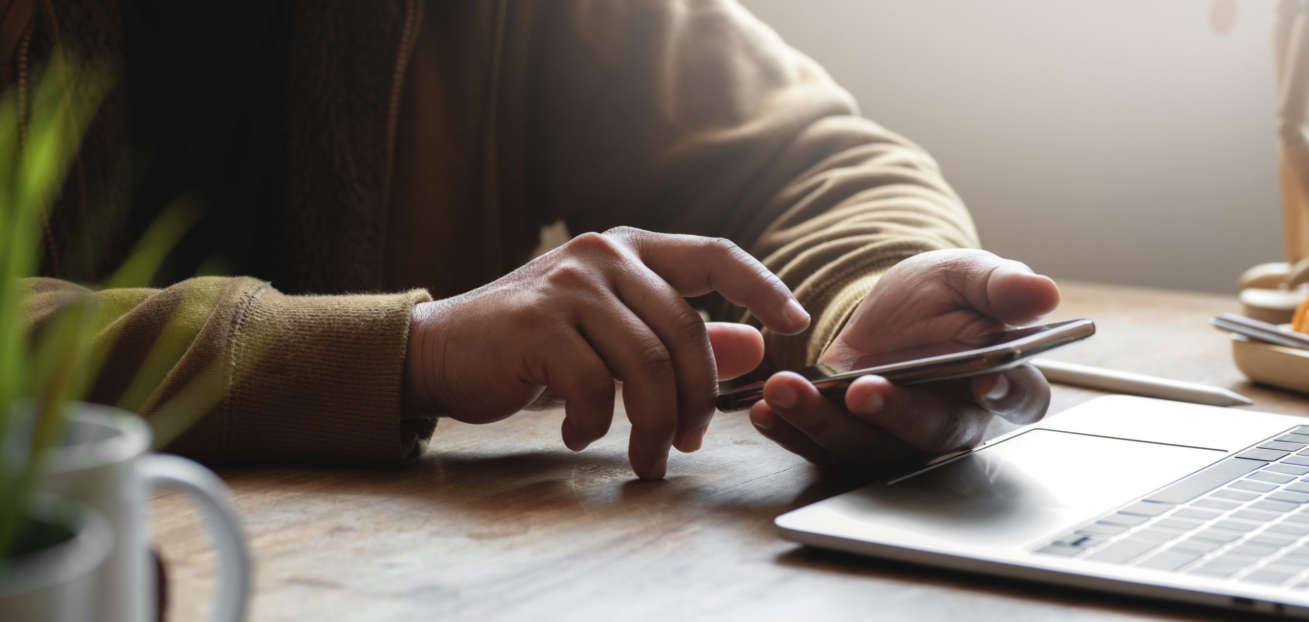 person-in-brown-long-sleeve-shirt-while-holding-smartphone. How to be productive working from home