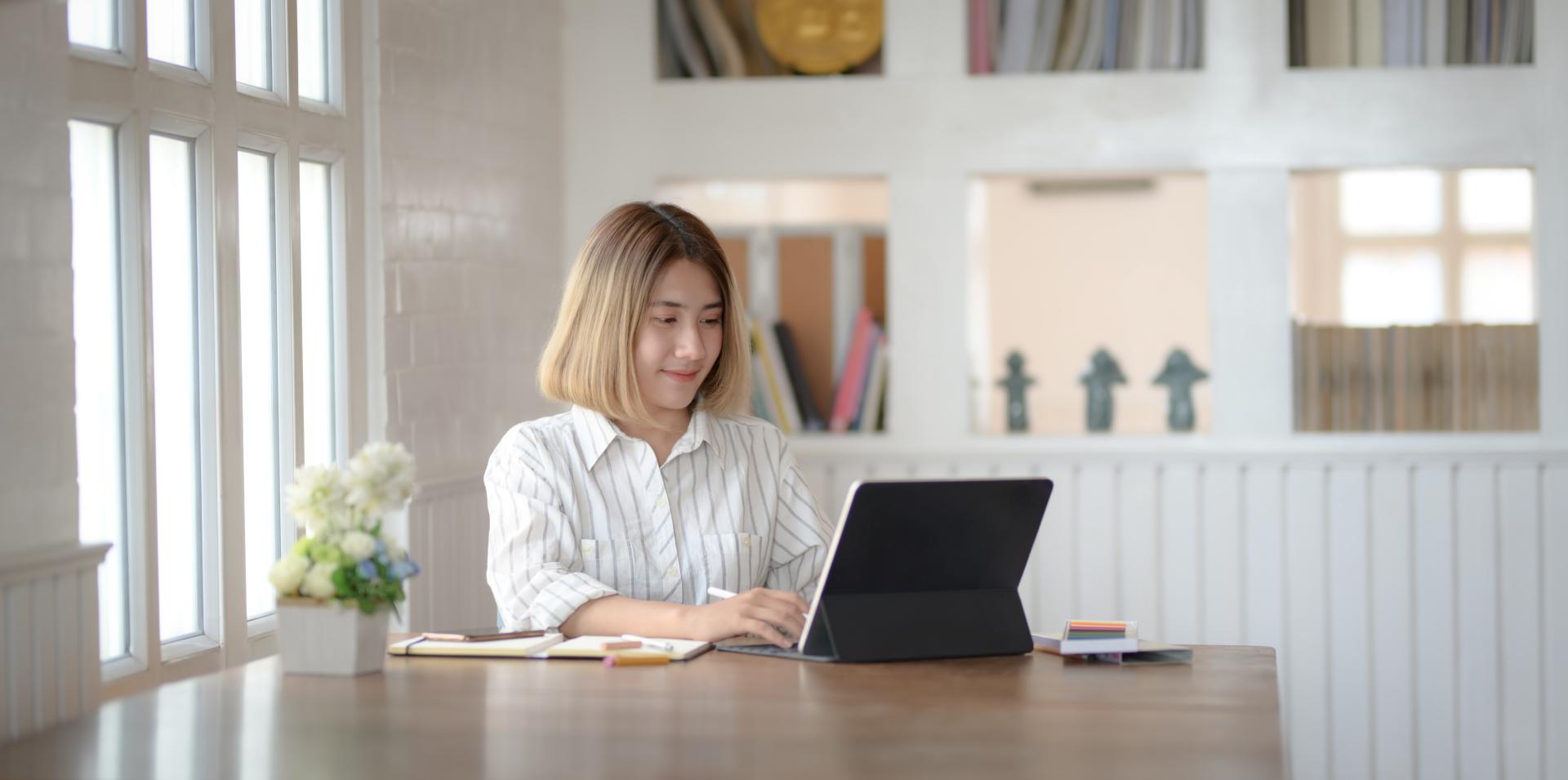 Lady working from home on Laptop in a very bright room