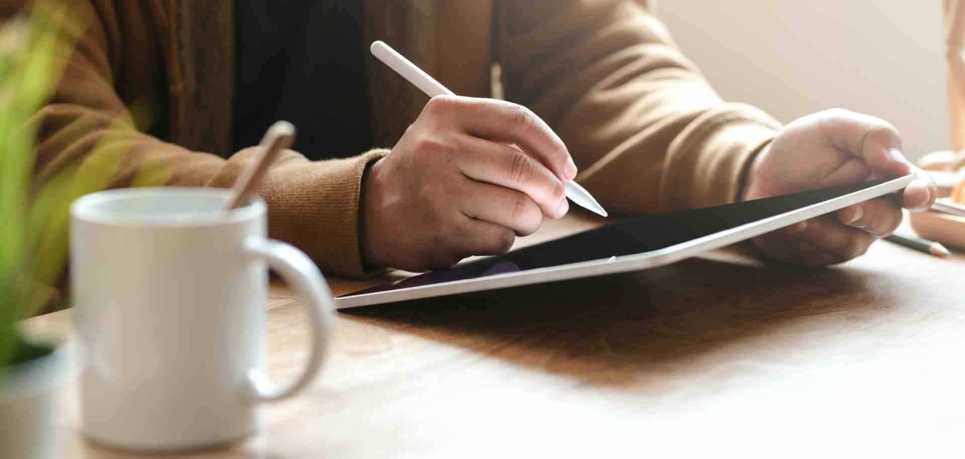 person-holding-white-pen-writing-on-tablet