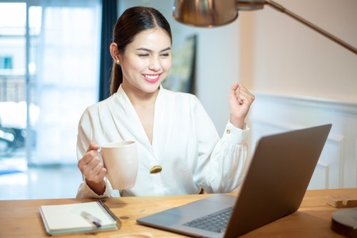 Woman hold coffee cup and clenching fists for success. Outlook training for executive assistants