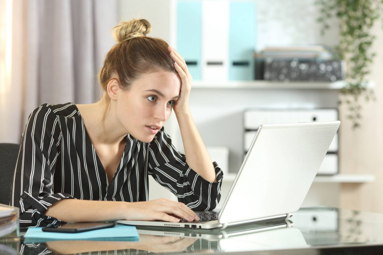 Worried business woman looking for an email on her laptop she knows she has seen when using Focused Inbox